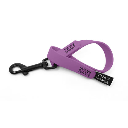 A lilac keeper in bio thane with a black trigger clip on a white background.