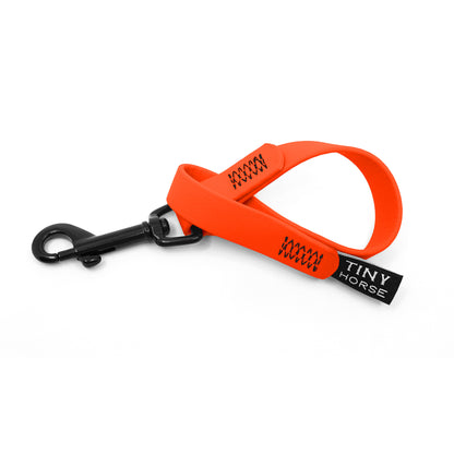 A neon orange keeper in bio thane with a black trigger clip on a white background.
