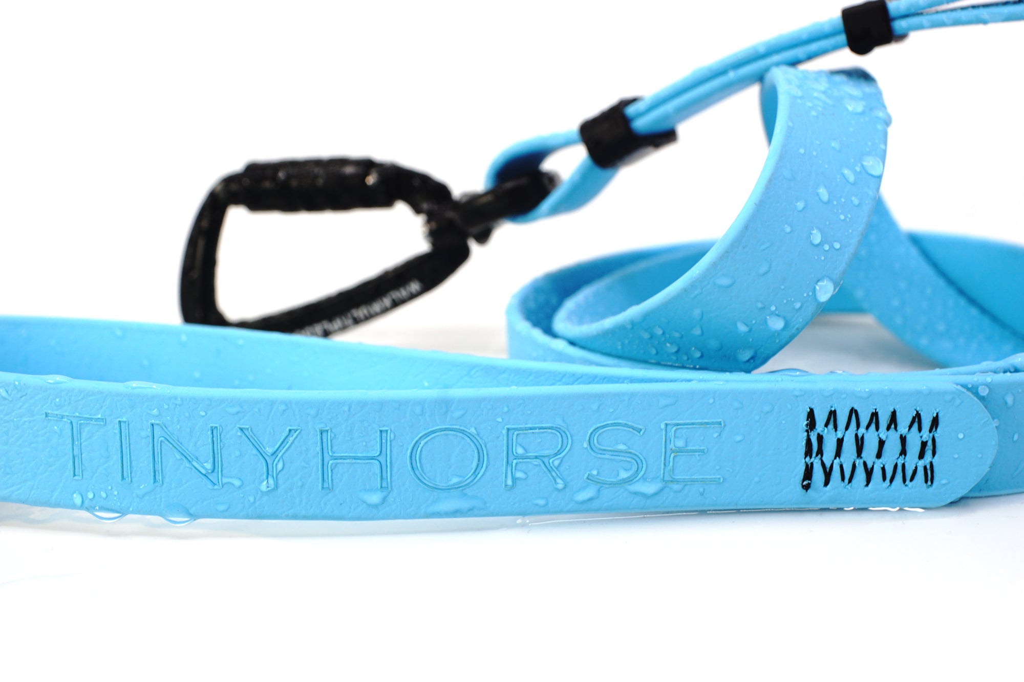 Close-up details of a blue waterproof dog leash with water droplets on it and 'Tiny Horse' branding on a white background