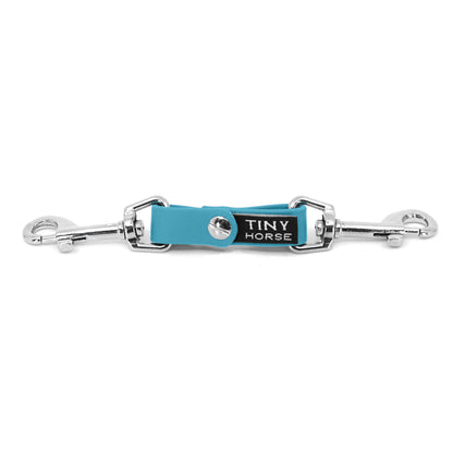 A baby blue security strap on bio thane with two silver triggers on a white background.