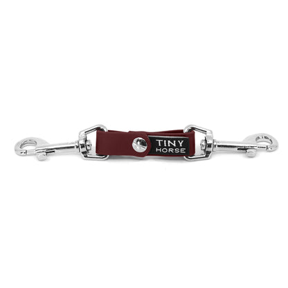 A burgundy security strap on bio thane with two silver triggers on a white background.