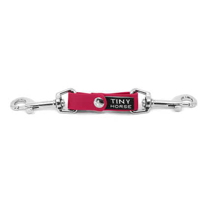 A raspberry security strap on bio thane with two silver triggers on a white background.
