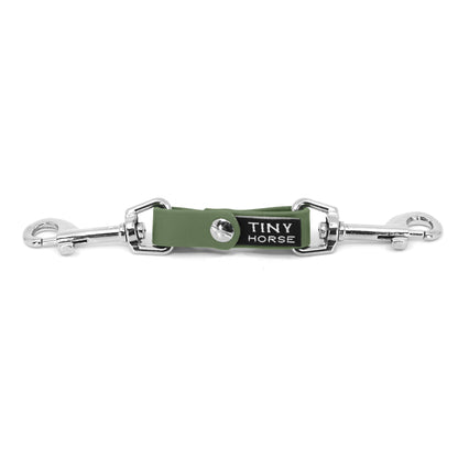 A sage security strap in bio thane with two silver triggers on a white background.