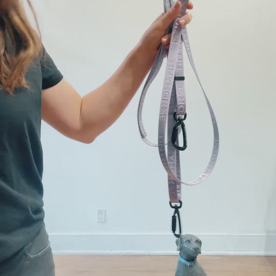 Demonstration of how the infinite is used to walk one dog hands free. It’s a long, ten-foot leash. It’s demonstrated how you tie a knot to create a loop that you slip the carabiner clip into. This turns the Infinite into a waist or crossbody dog walking belt. There is a secure auto-locking clasp to clip onto your dog. As well, a three-level traffic handle that gives ample hands-on control when needed. 